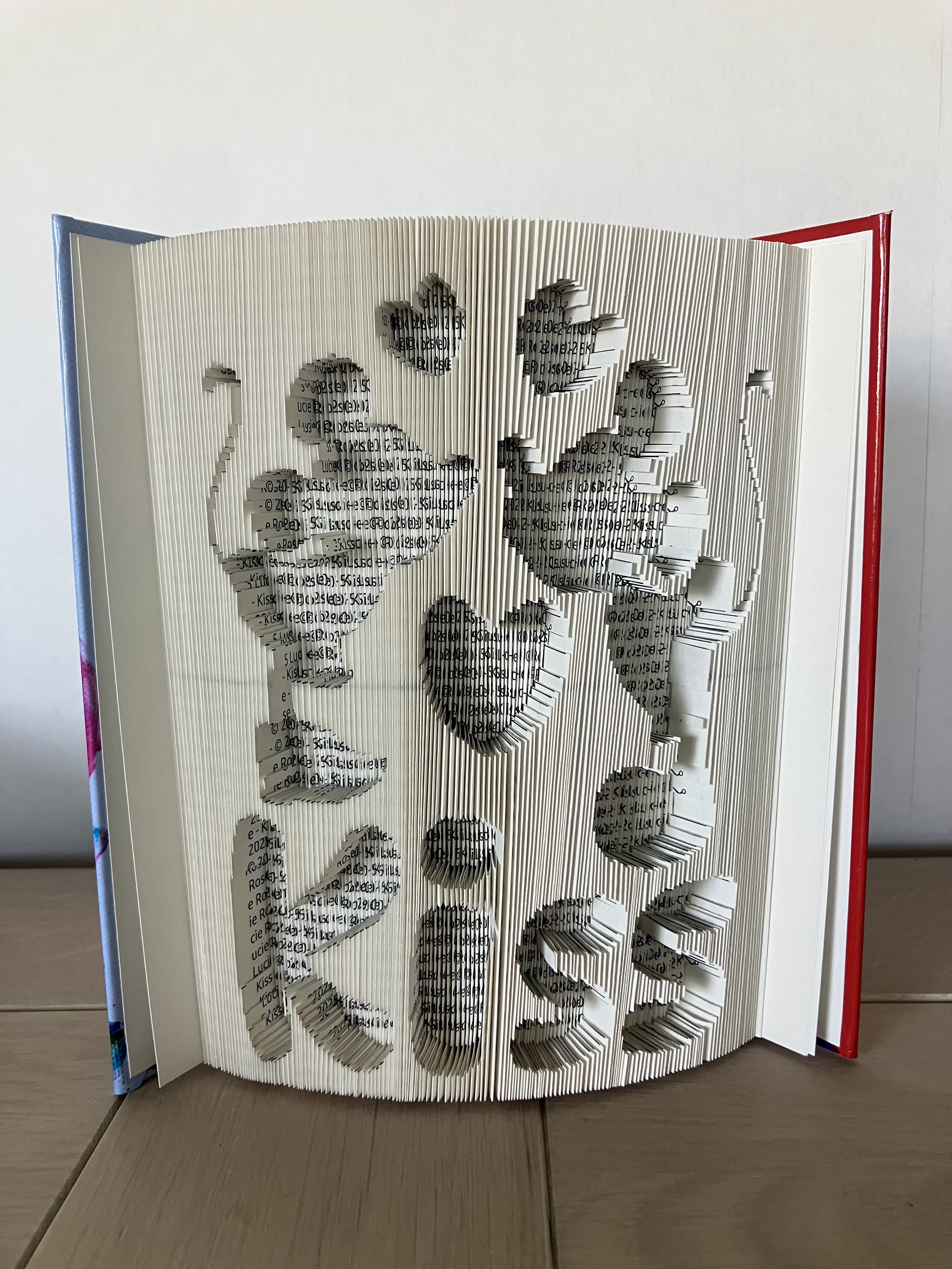 Exemple de livre sculpté avec prénom découpé dans les pages - création artistique personnalisée Lucie-Rose